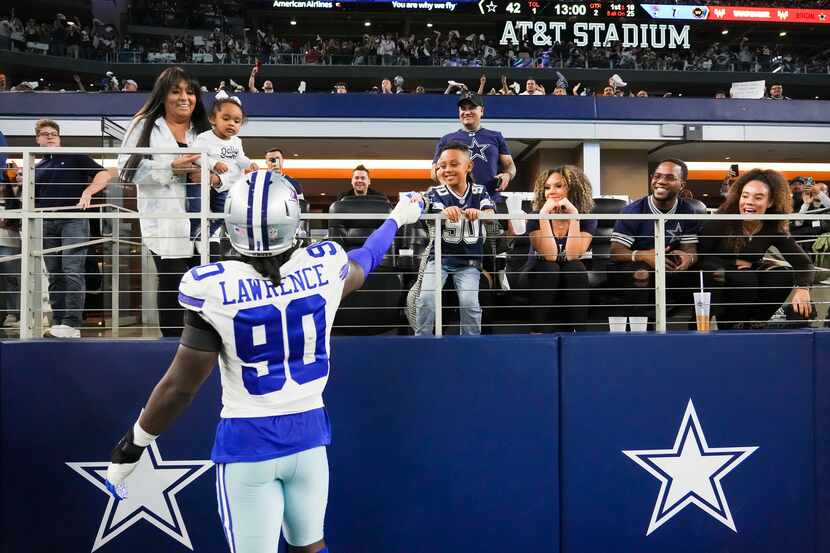 Dallas Cowboys defensive end Demarcus Lawrence (90) celebrates with his family ass he leaves...