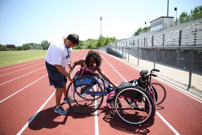 Rowlett High School track and field coach David Nanez of Rowlett, helps senior Brandi Smith,...