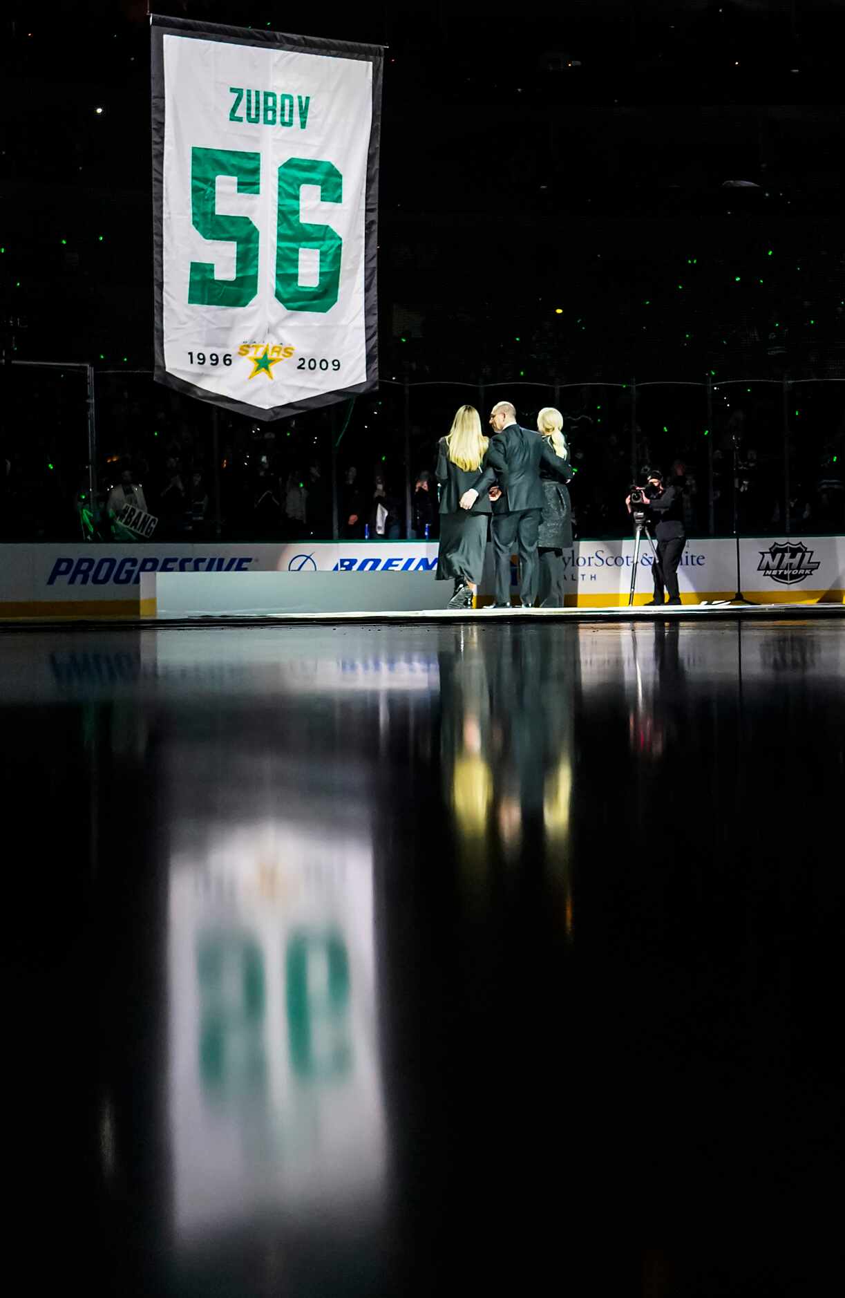 Former Dallas Stars player Sergei Zubov stands with his wife and daughter as a banner...