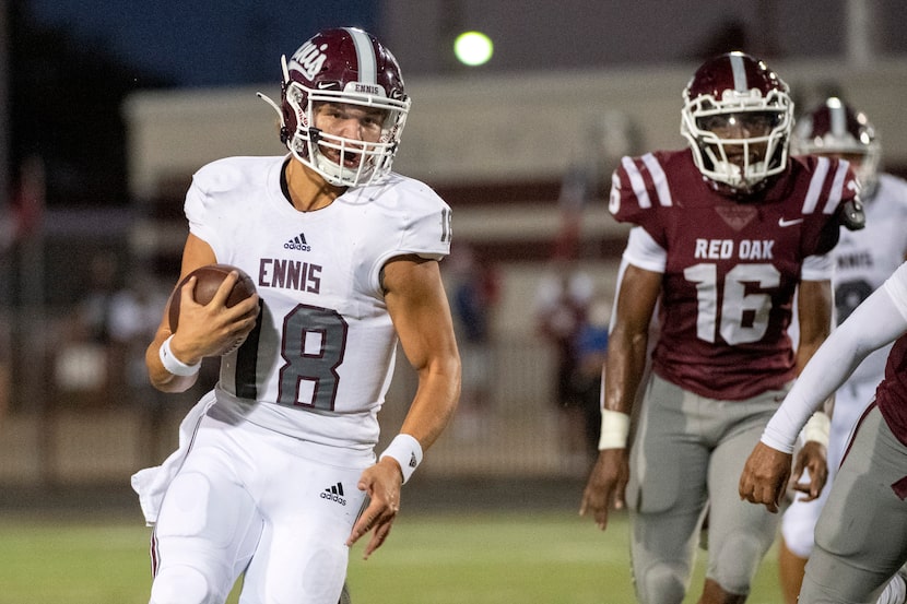 Ennis senior quarterback Collin Drake (18) turns upfield past Red Oak senior Devin Steen...