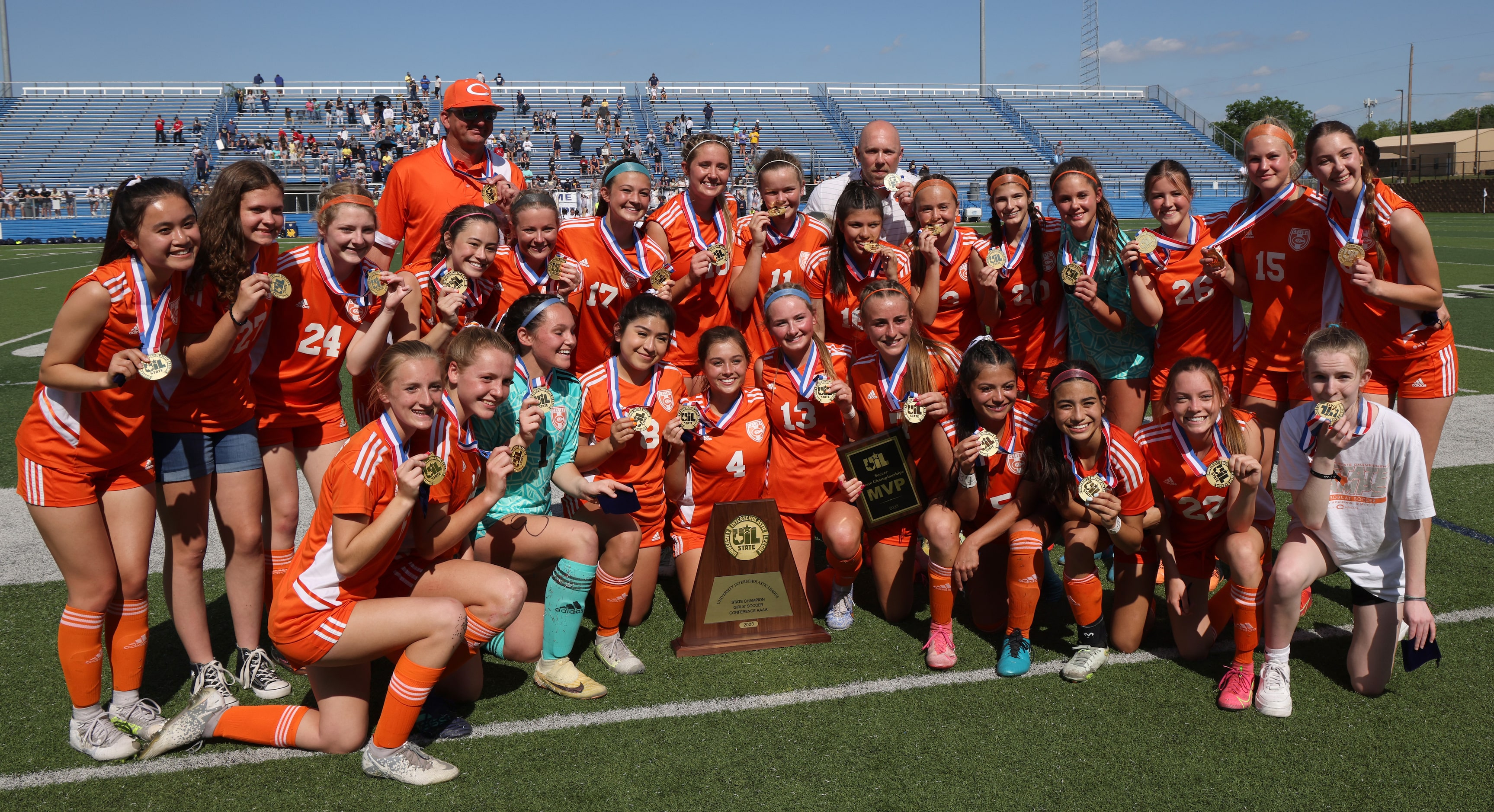 Celina players and coaches pose with the state championship trophy following their 8-1...