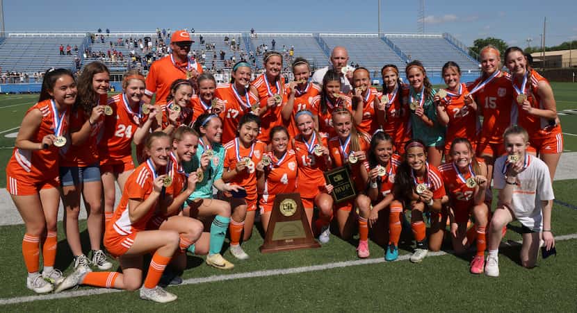 Celina players and coaches pose with the state championship trophy following their 8-1...