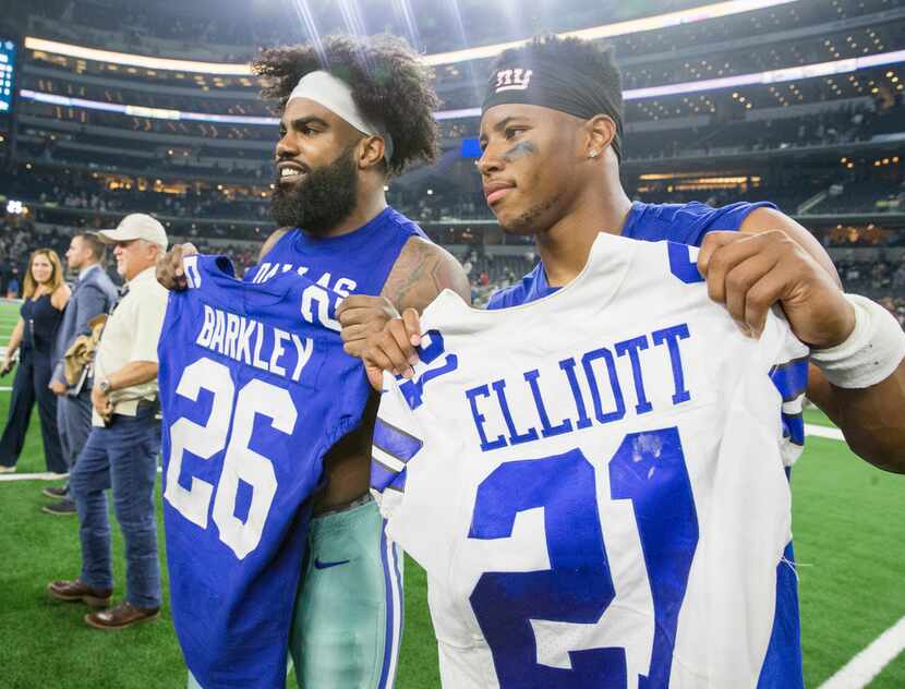 Dallas Cowboys running back Ezekiel Elliott (21) poses for pictures after exchanging jerseys...