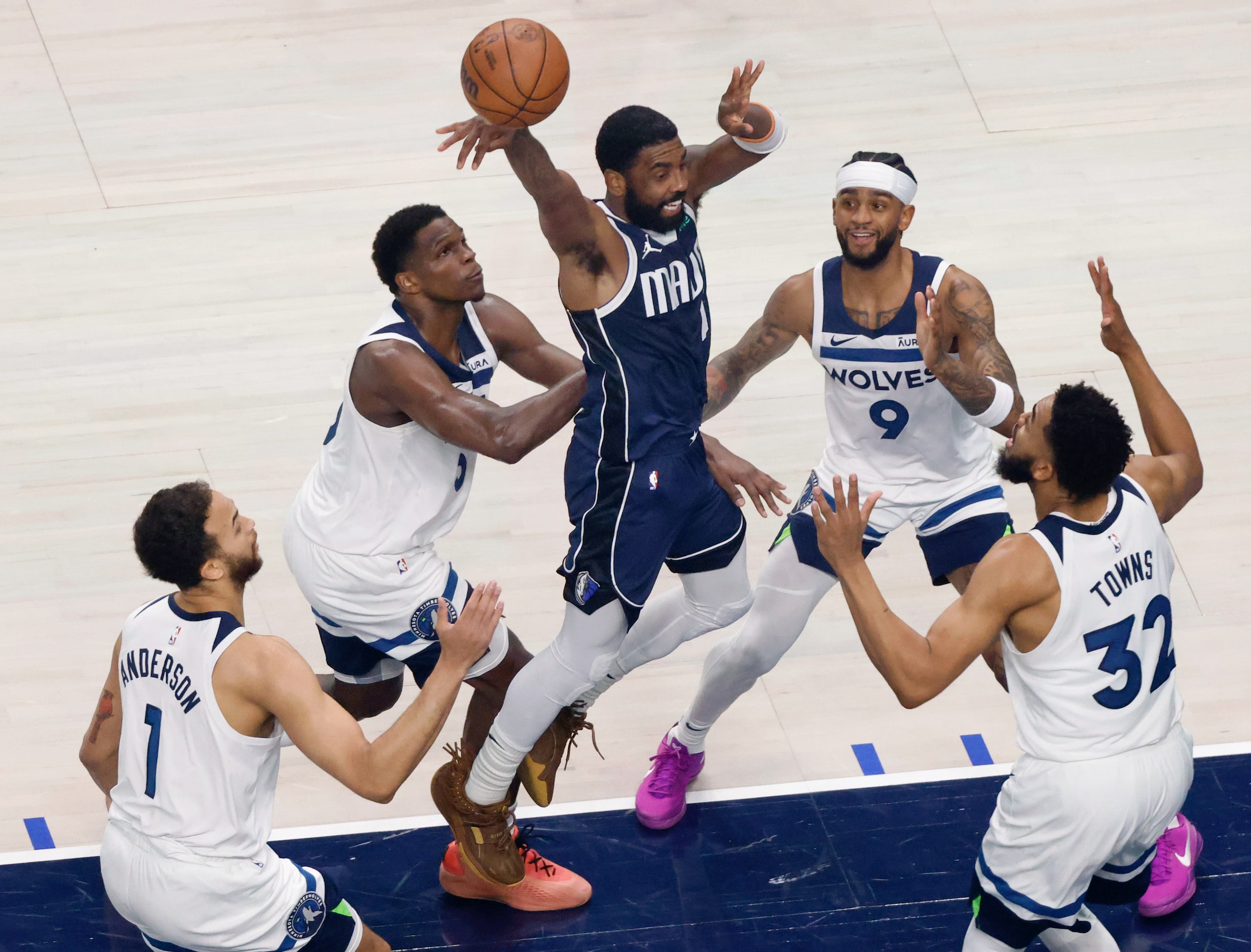 Dallas Mavericks guard Kyrie Irving (11) dishes the ball off as he drives the lane against...