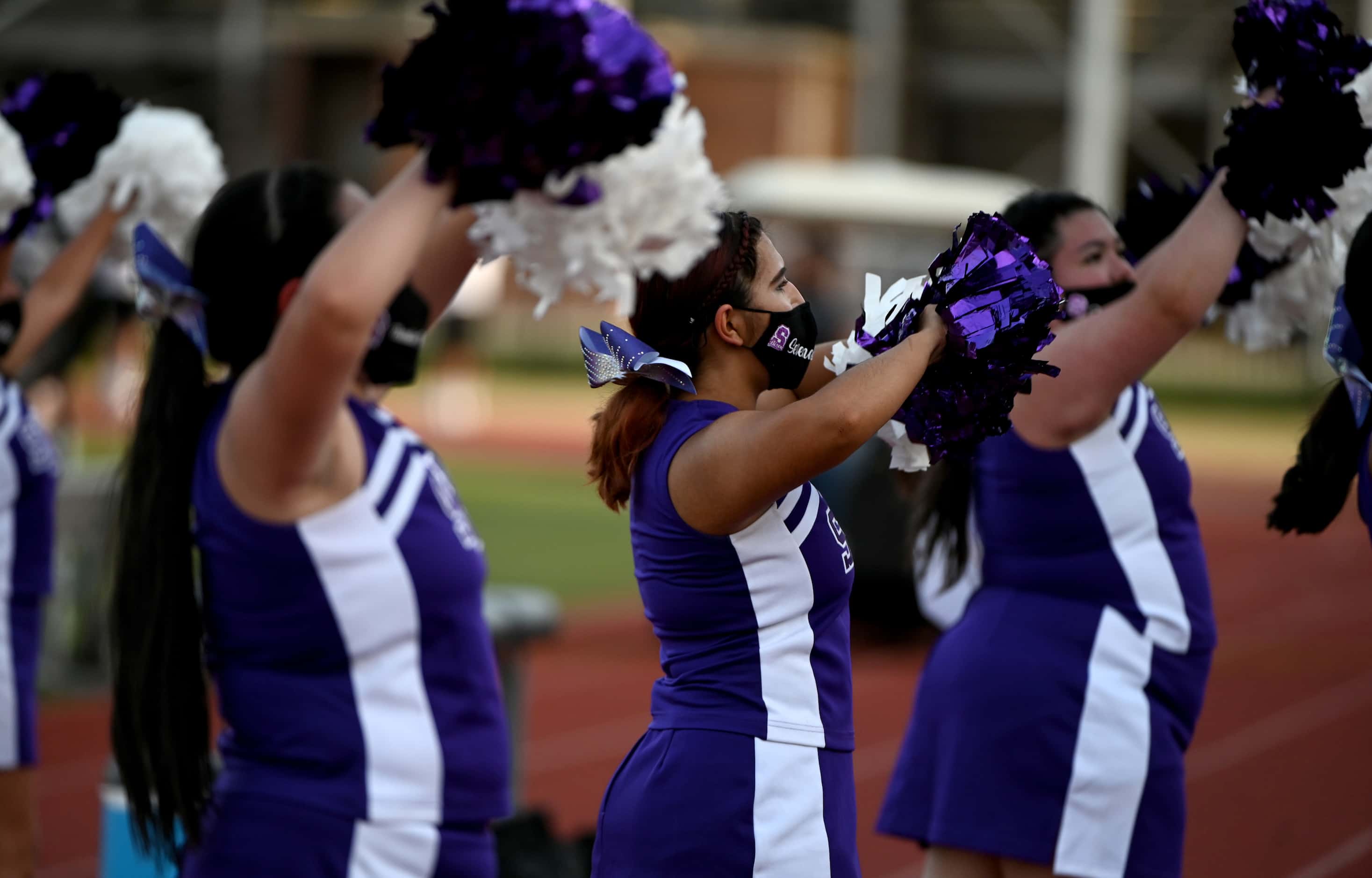 Sunset cheerleaders perform in the first half during a high school football game between...