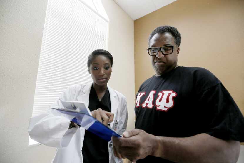 Dr. Donta Bennett, left, reviews with then-Dallas City council member Dwaine Caraway his...