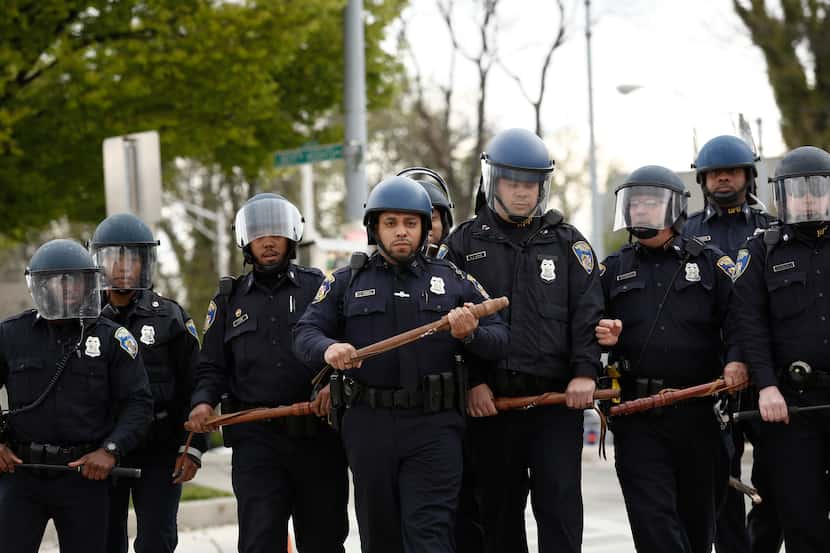 BALTIMORE, MD - APRIL 27:  Baltimore Police officers in riot gear walk toward protestors...