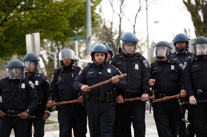 BALTIMORE, MD - APRIL 27:  Baltimore Police officers in riot gear walk toward protestors...