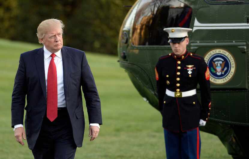 U.S. President Donald Trump walks on the south lawn on Sunday, April 9, 2017 after arriving...