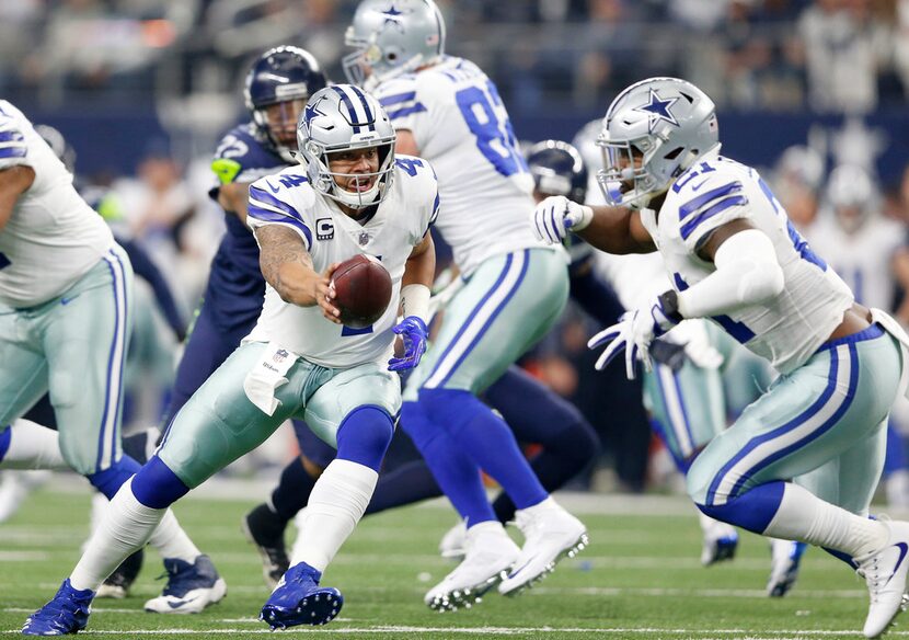 Dallas Cowboys quarterback Dak Prescott (4) hands the ball off to Dallas Cowboys running...