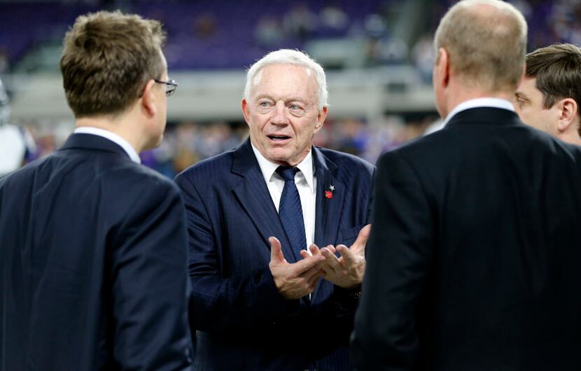 Dallas Cowboys owner Jerry Jones, center, stands on the field before an NFL football game...