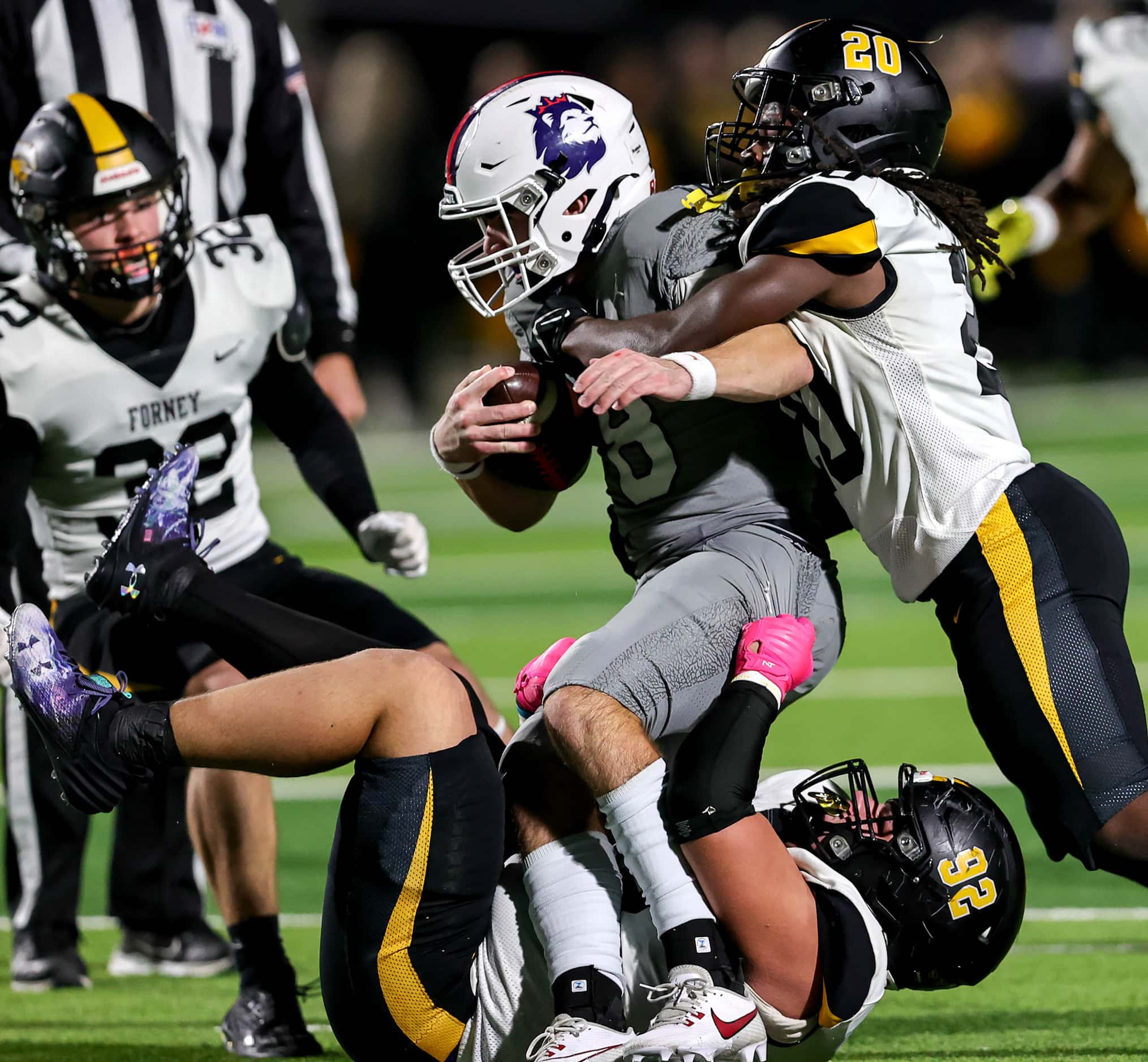 Richland quarterback Drew Kates (8) gets stopped for a short gain by Forney defensive...