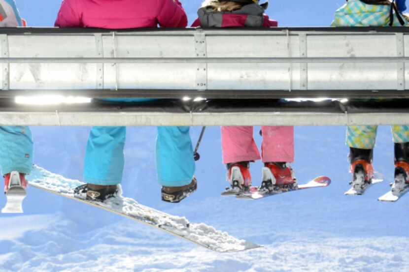 In this Dec. 14, 2013 photo, skiers and a lone snowboarder ride a lift at Durango Mountain...