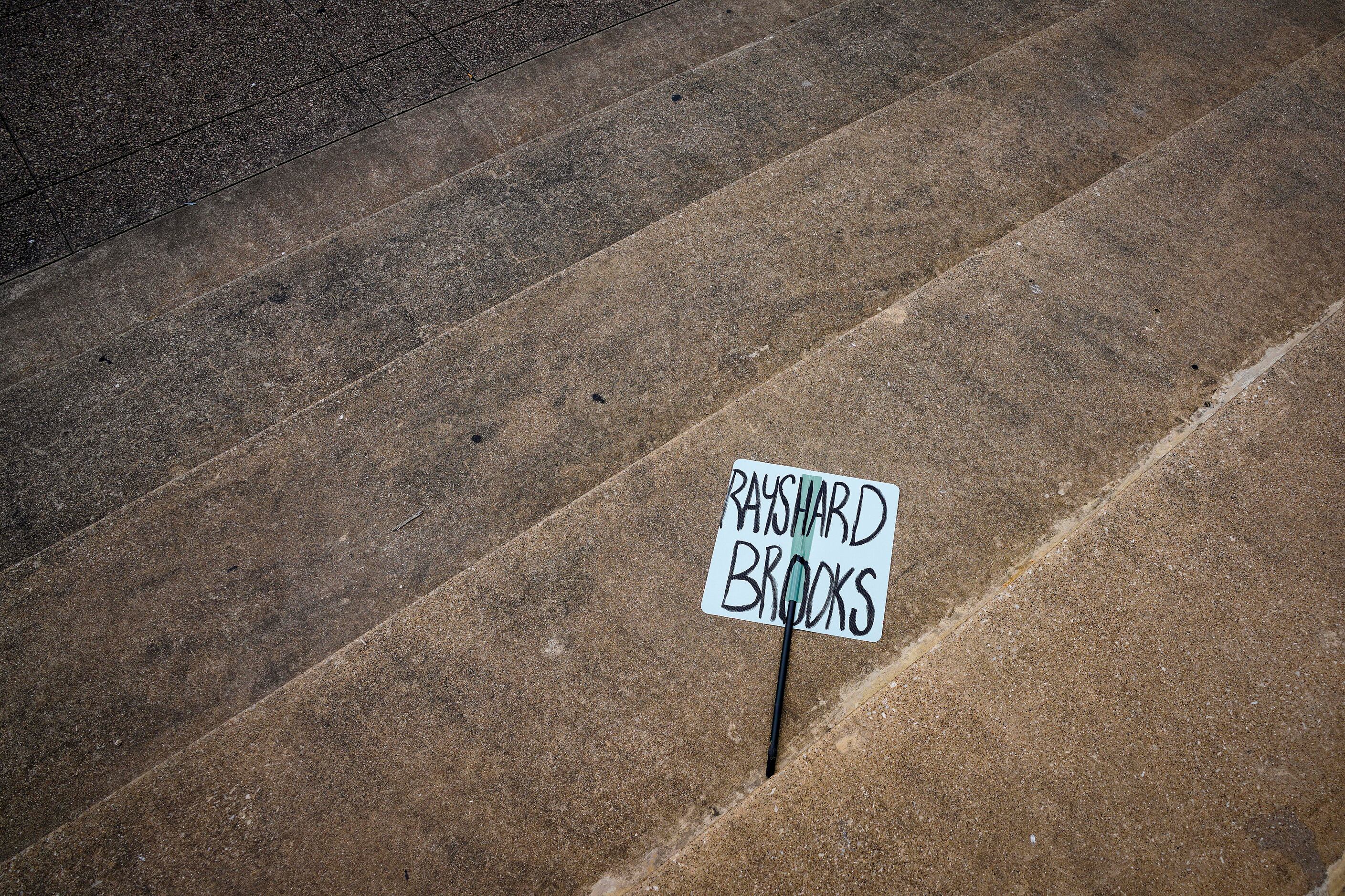 A sign bearing the name of Rayshard Brooks is left behind on the steps as demonstrators at a...