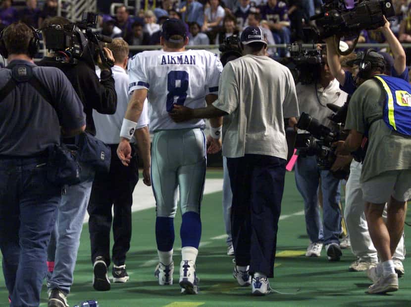 Minneapolis, MN -- Dallas Cowboys' Troy Aikman walks off the field with Michael Irvin...