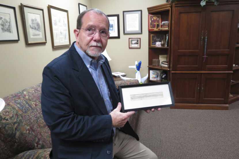 The Rev. Dennis Wilkinson holds a rubbing from the Vietnam Memorial in Washington bearing...
