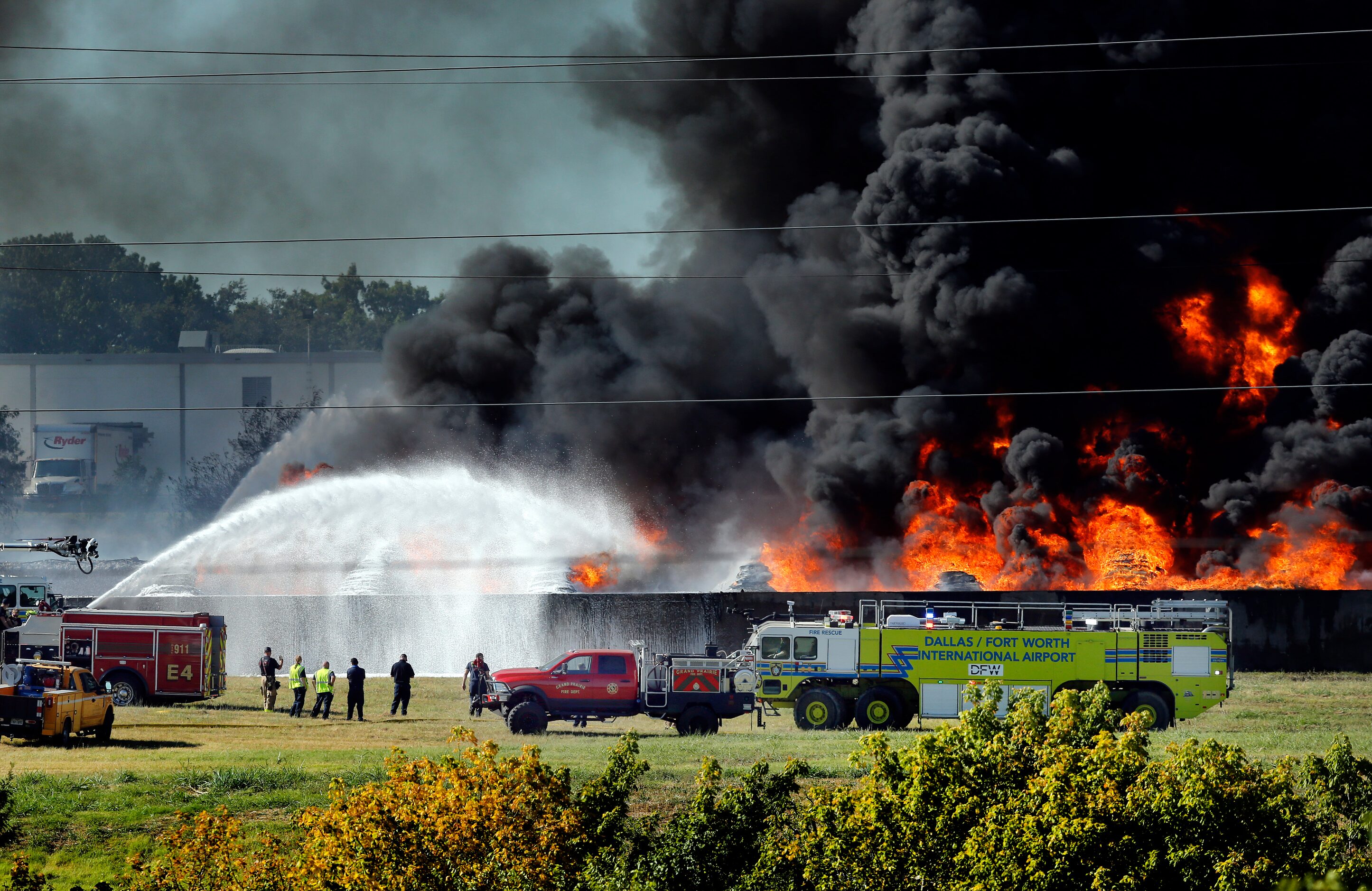 Grand Prairie and DFW International Airport firefighters douse burning plastic which caught...