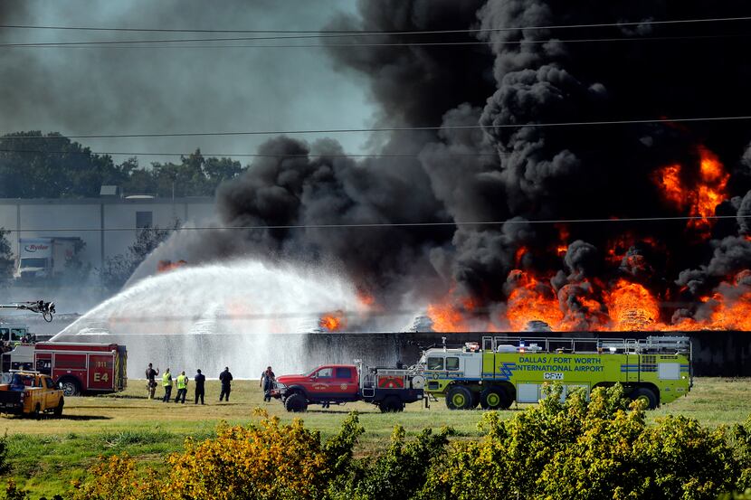 Grand Prairie and D/FW Airport firefighters douse burning plastic which caught fire at...