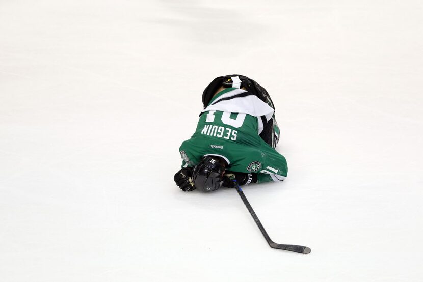 Dallas Stars center Tyler Seguin (91) lies face down on the ice after being deliberately hit...