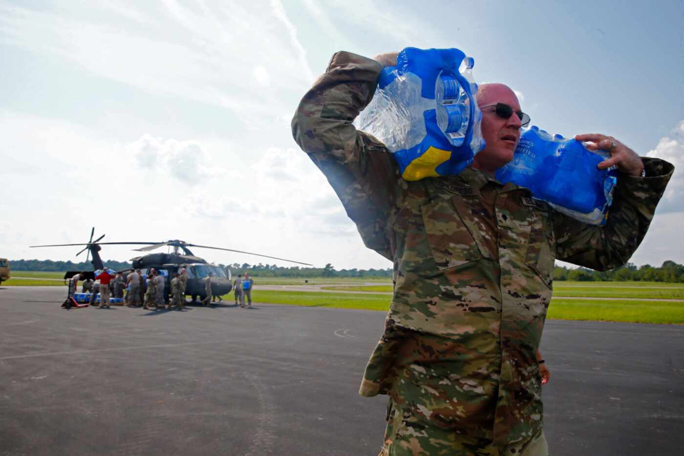 Sgt. Kevin Childress unloads water with the Texas National Guard (4th Battalion, 133rd...