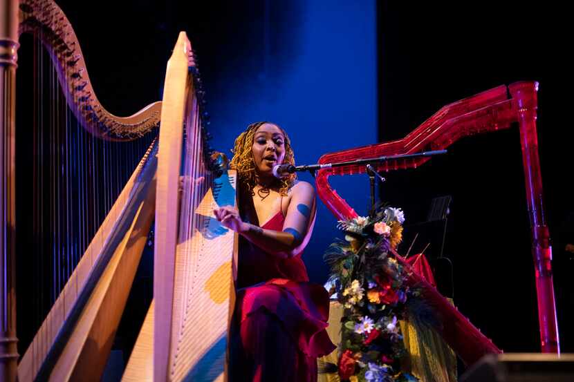 Jess Garland sings and plays the harp barefoot as video projections play in the background.