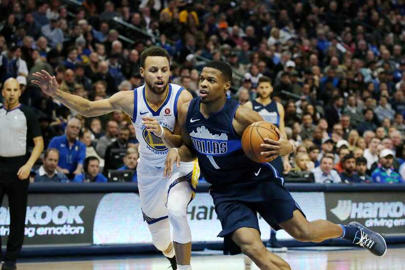 The Golden State Warriors' Stephen Curry (30) defends against the' Dallas Mavericks' Dennis...
