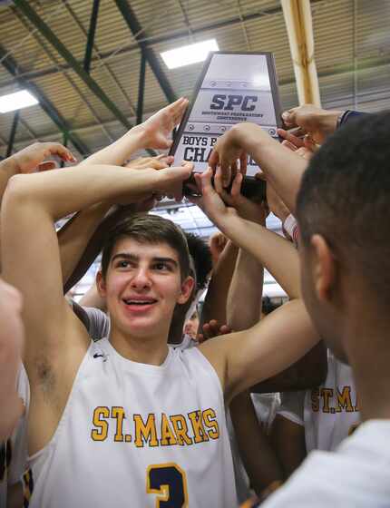 St. Mark's Corvin Oprea (3) holds up the trophy with his team after winning a SPC boy's...