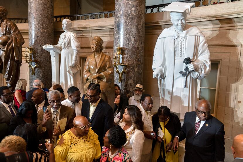 Evelyn Bethune, front left in yellow, a granddaughter of Mary McLeod Bethune, speaks with...