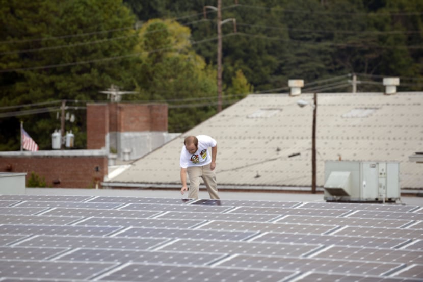Mike Easterwood checks the solar panels atop his self-storage business near Atlanta. He says...