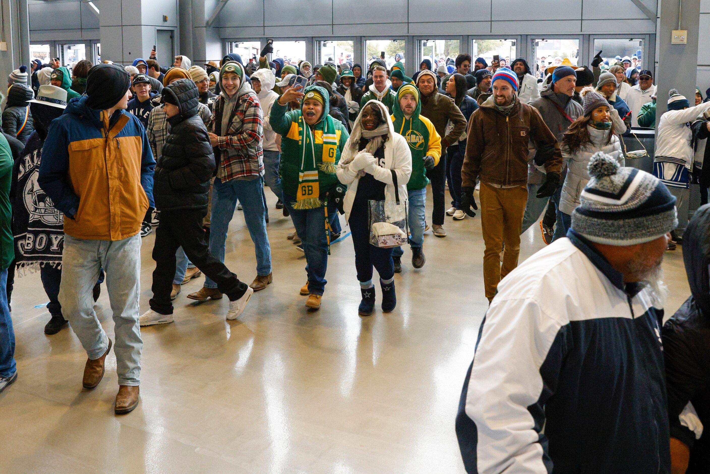 Fans make their way inside AT&T Stadium before an NFL wild card playoff game between the...