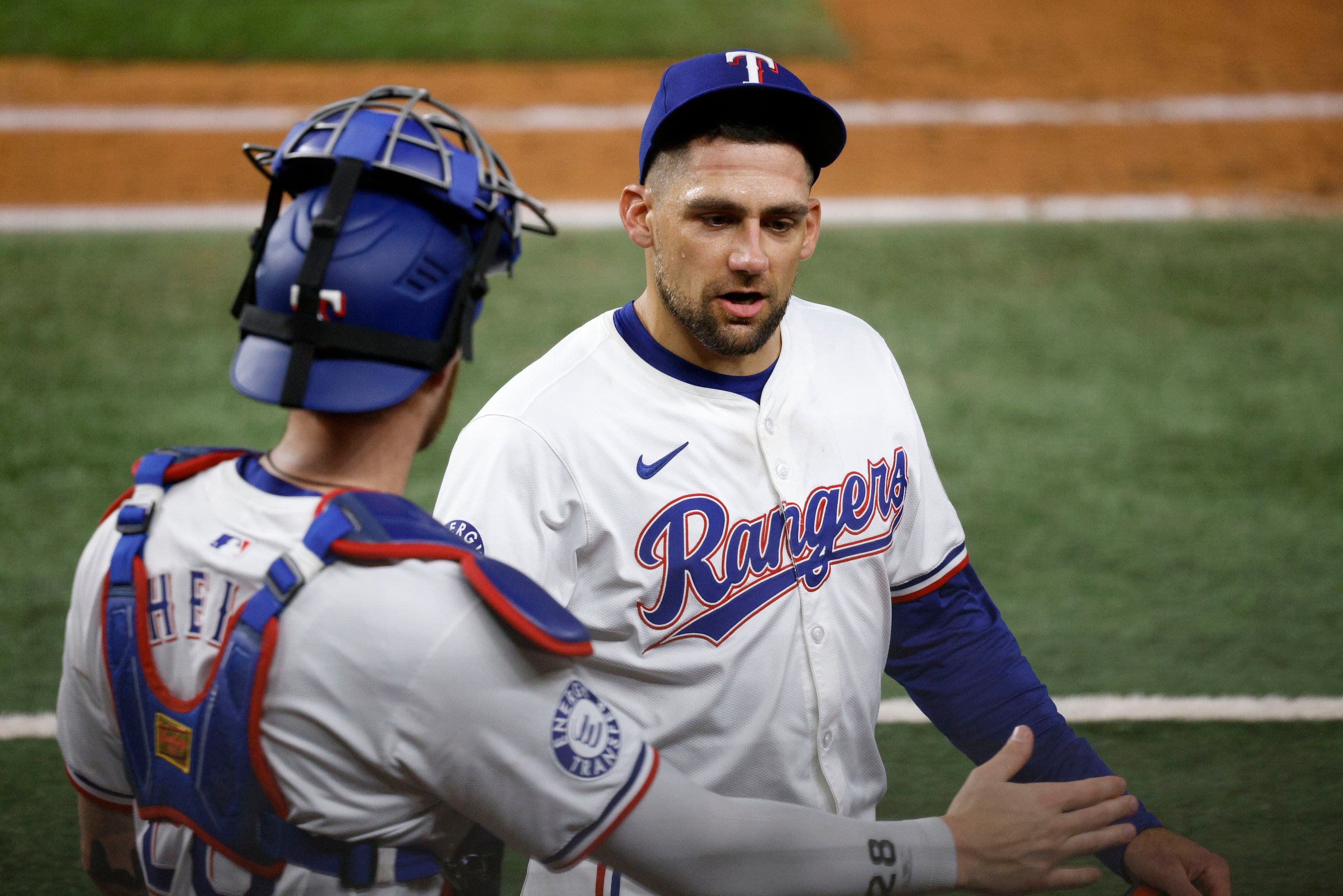 Texas Rangers pitcher Nathan Eovaldi (17) gets a high-five from his teammate catcher Jonah...