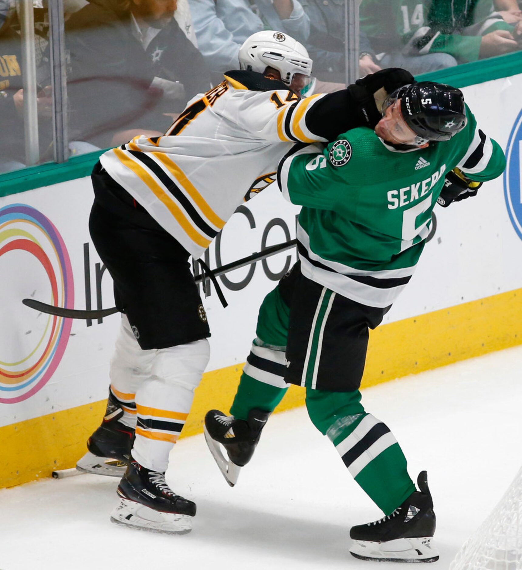 Boston Bruins right wing Chris Wagner (14) pushes Dallas Stars defenseman Andrej Sekera (5)...