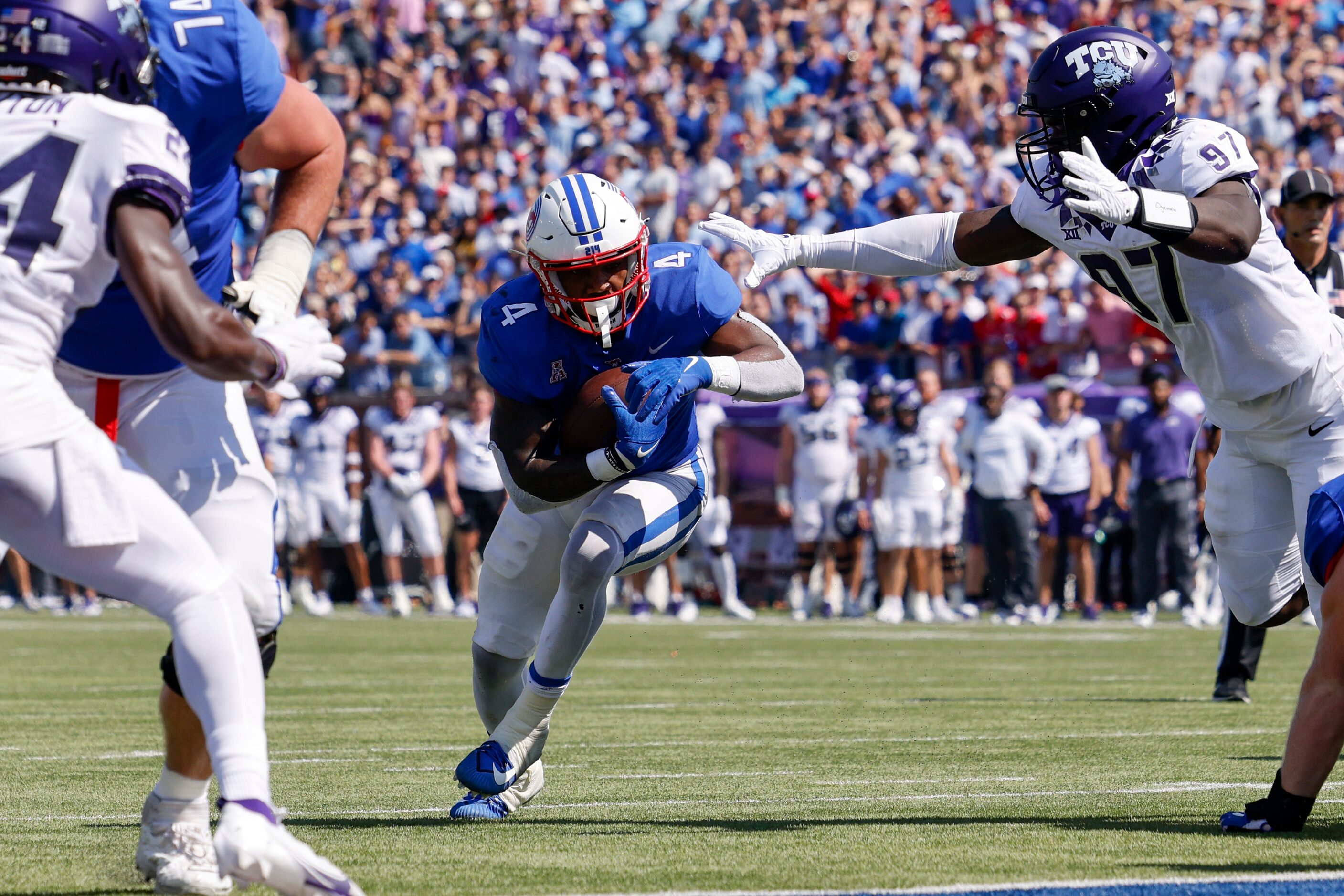 SMU running back Tre Siggers (4) slips underneath the arm of TCU defensive lineman Paul...