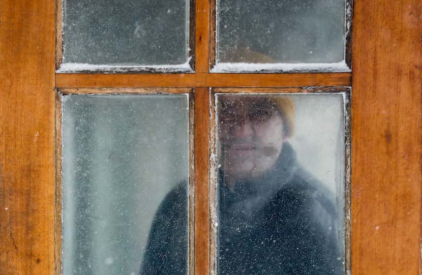 YONKERS, NY: A man peers through a fogged and snow blown window while watching for a delayed...