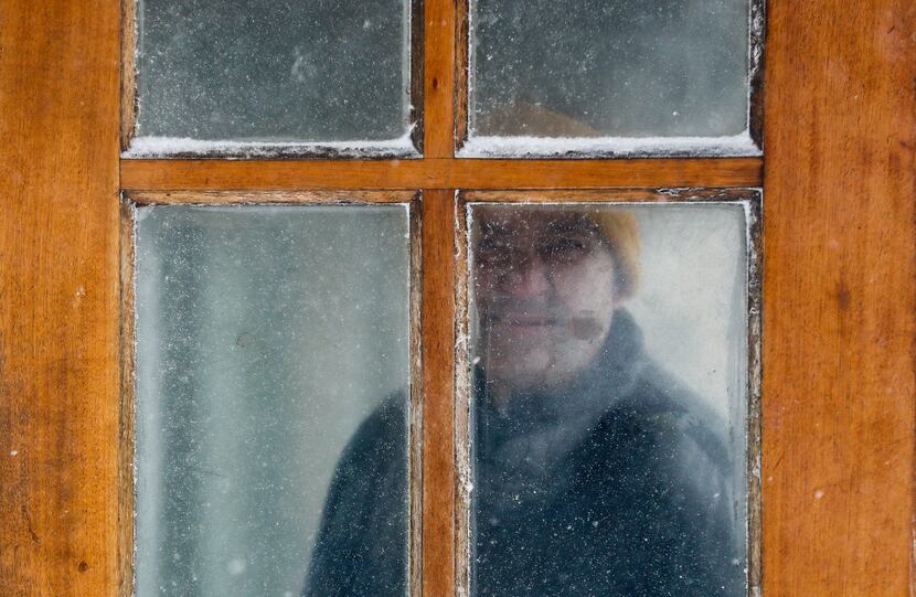 YONKERS, NY: A man peers through a fogged and snow blown window while watching for a delayed...