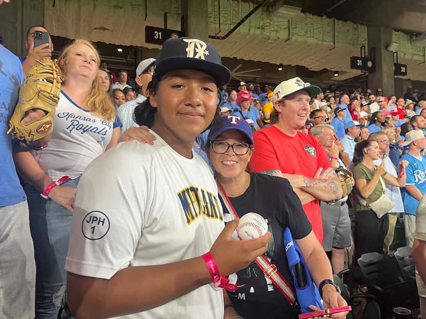 George Lugo, 15, and his aunt Patty Lentz pose for a photo after Lugo caught a homer hit by...