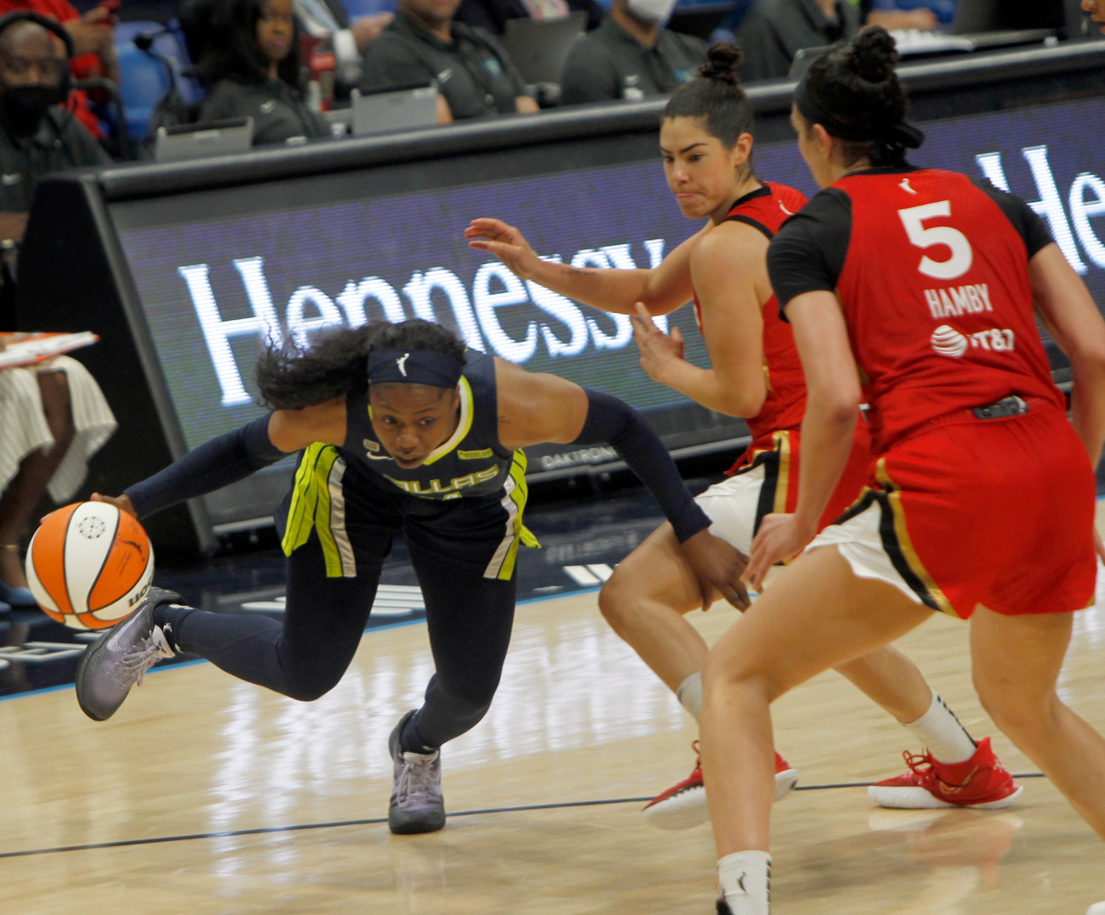 Dallas Wings guard Arike Ogunbowale (24), left, drives under the defense of Las Vegas guard...