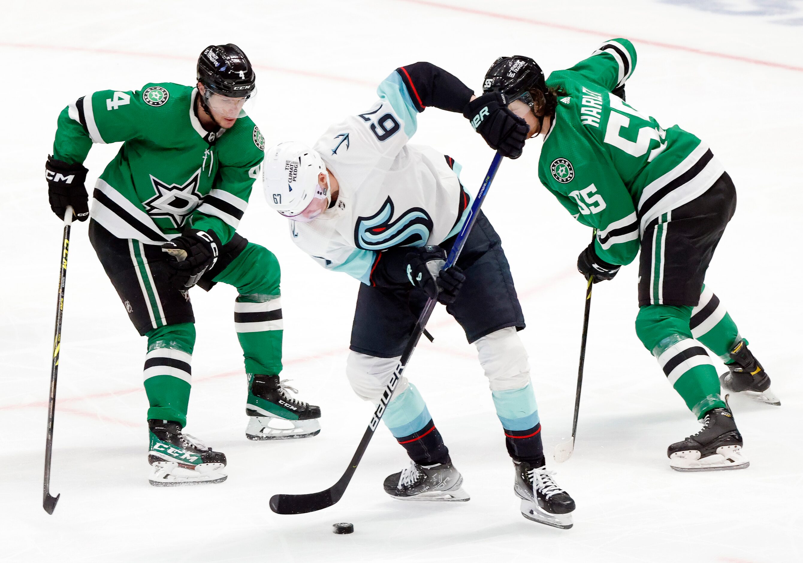 Dallas Stars defenseman Miro Heiskanen (4) and Thomas Harley (55) attempt to steal the puck...