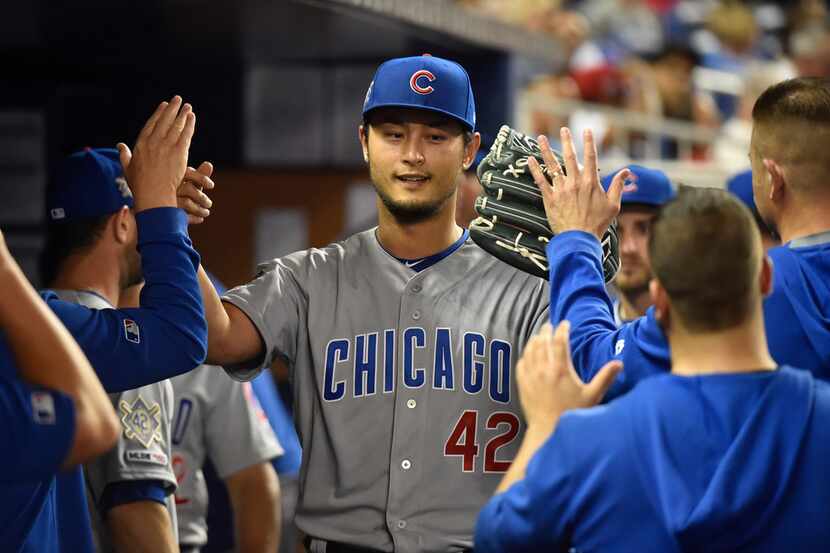 MIAMI, FL - APRIL 15: Yu Darvish #11 of the Chicago Cubs is congratulated by teammates after...