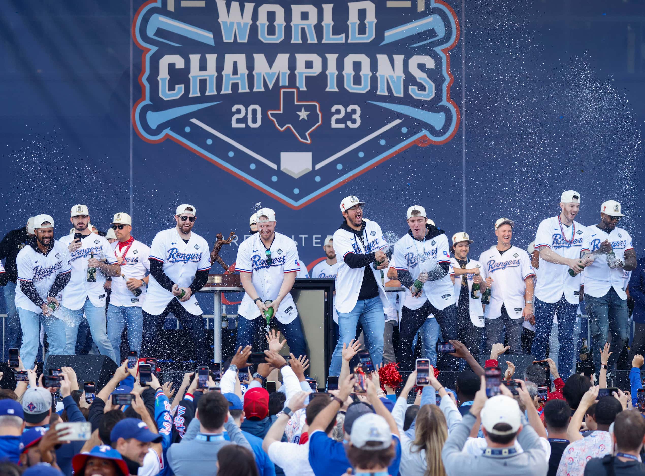 Texas Rangers players spray champagne during post-parade public celebration on, Friday, Nov....