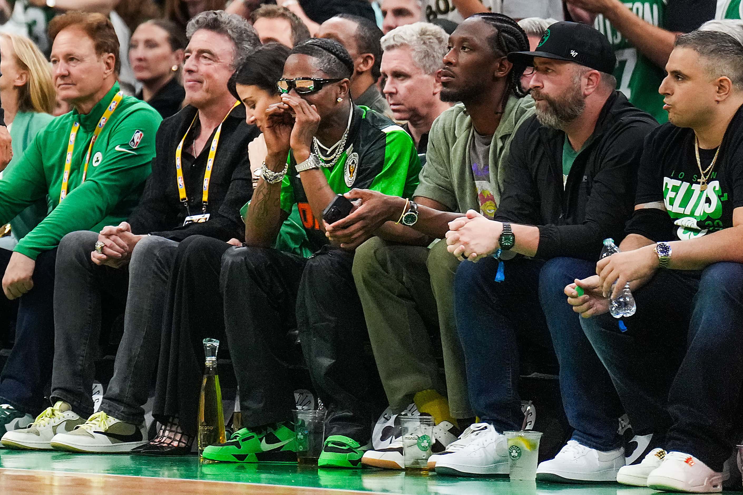 Rapper Travis Scott (with hands to face) watches the game from courtside seats during the...