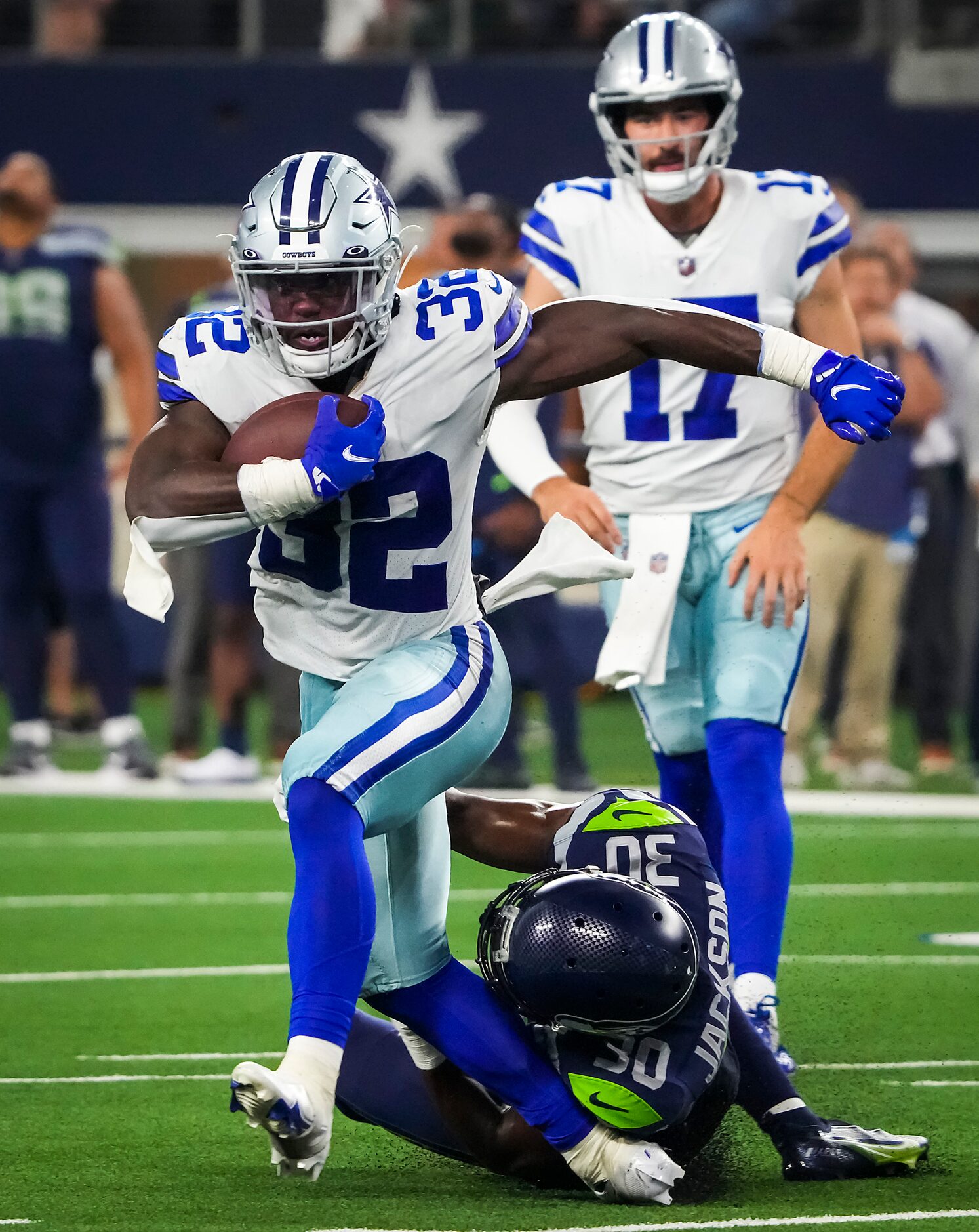 Dallas Cowboys running back Aaron Shampklin (32) has his right leg rolled up under Seattle...