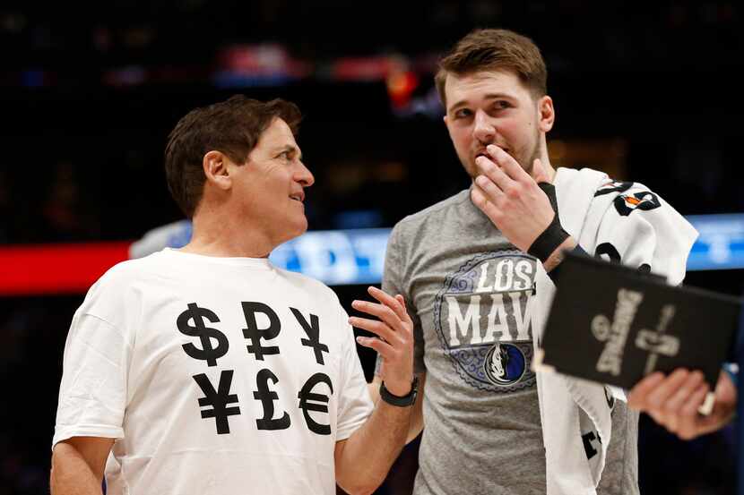 Dallas Mavericks owner Mark Cuban sports a shirt with money signs as he talks to Dallas...