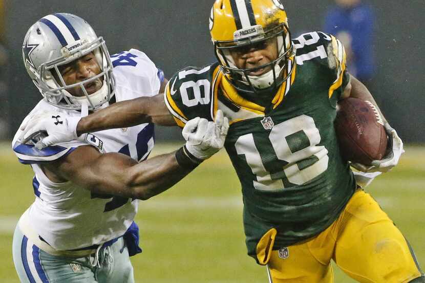 Green Bay Packers wide receiver Randall Cobb (18) tries to motor past  Dallas Cowboys strong...