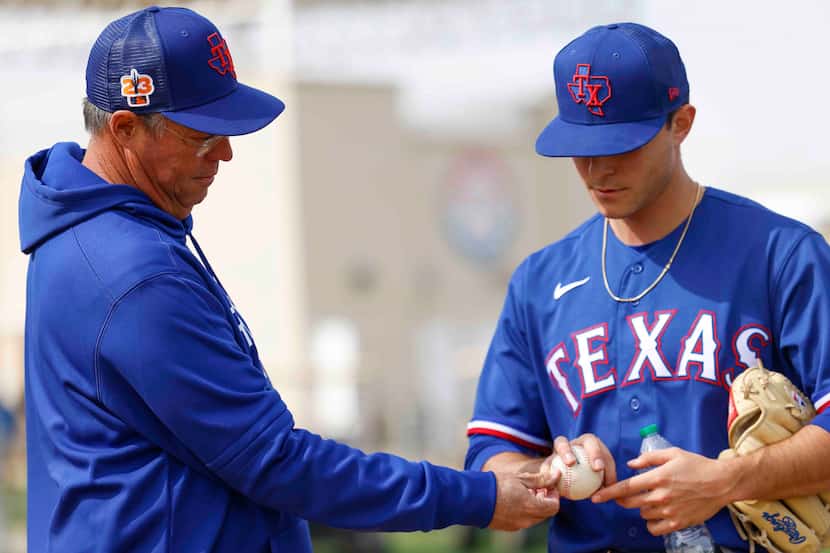 Texas Rangers special assistant Greg Maddux, left, gives pointers to pitcher Jack Leiter...