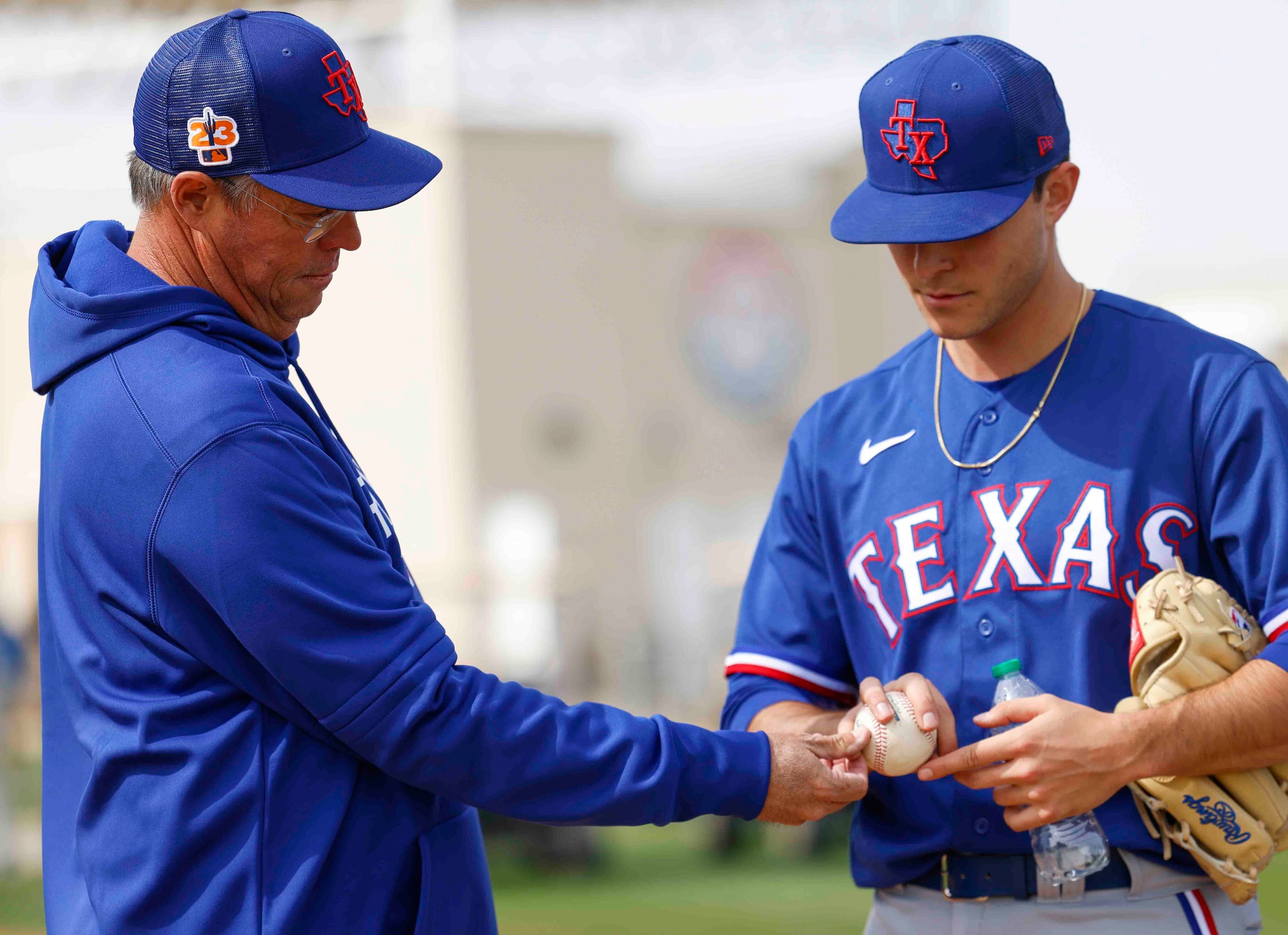 Texas Rangers special assistant Greg Maddux, left, gives pointers to pitcher Jack Leiter...