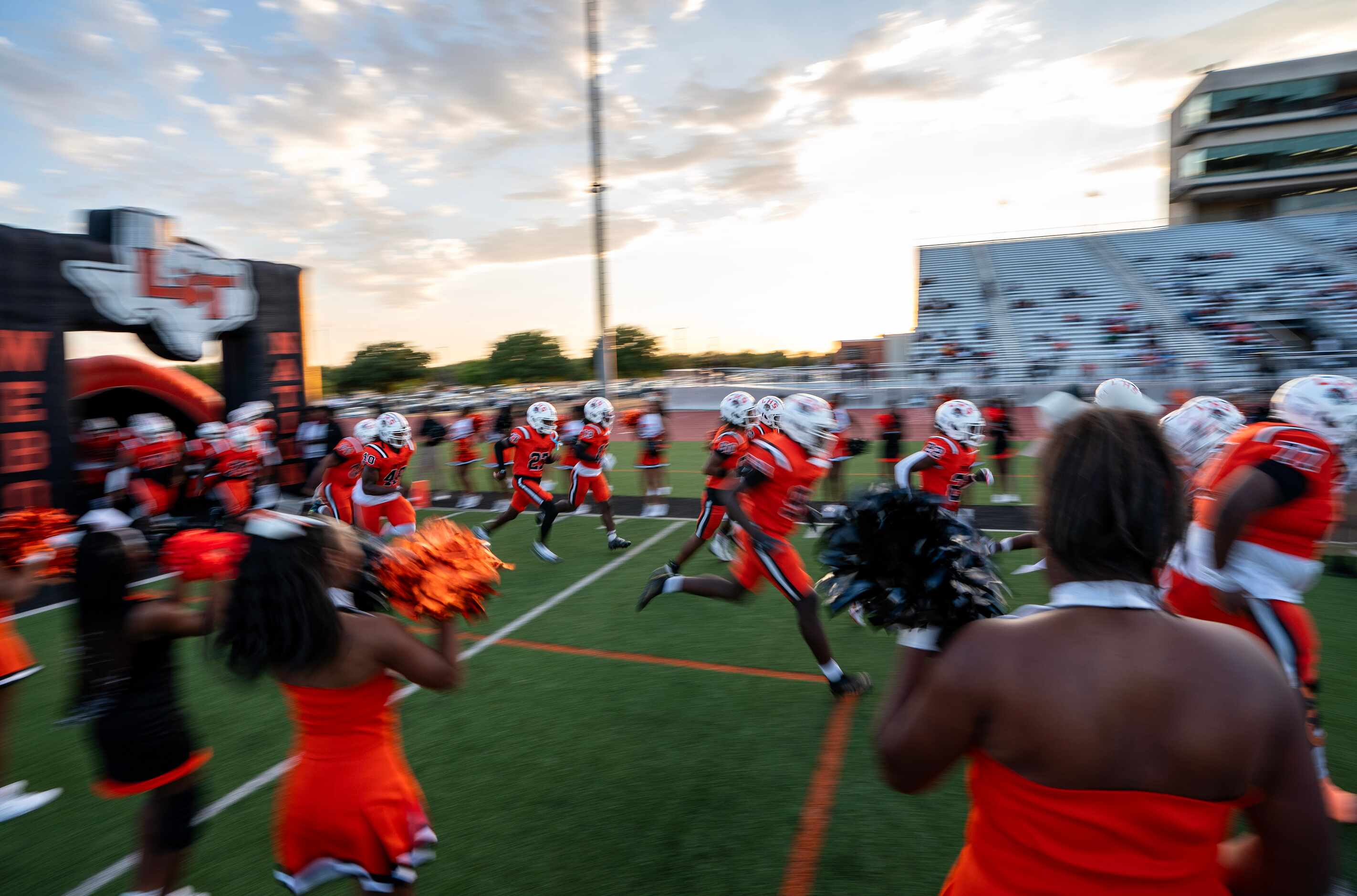 The Lancaster Tigers take the field before a high school football game against Denton Guyer...