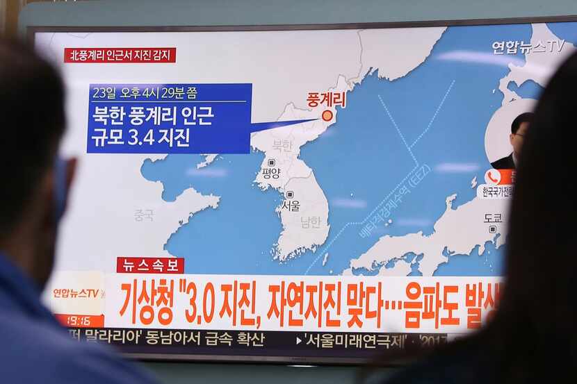 People watch a TV news program reporting North Korea's earthquake, at Seoul Railway Station...