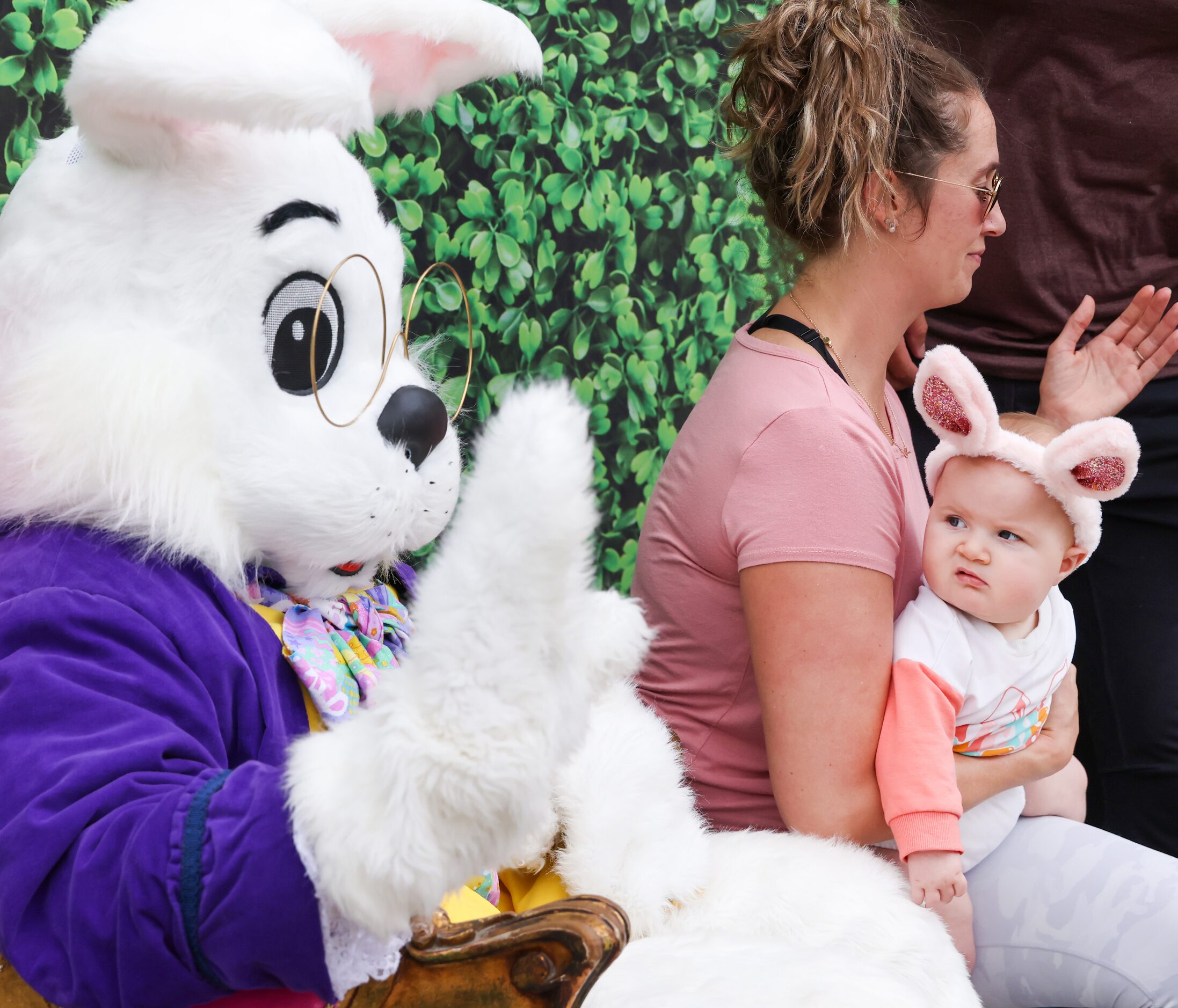 Tatum Weber, 6 months, turns to assess the Easter bunny while in the arms of Samantha DeMars...