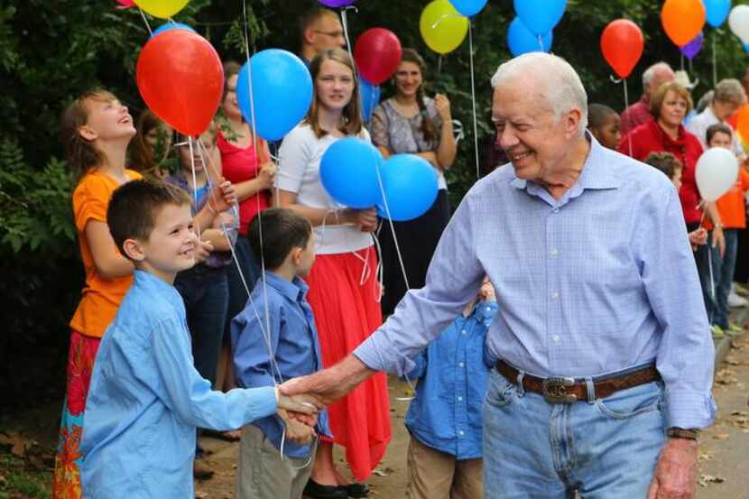 
Former President Jimmy Carter shakes hands with well wishers as he arrives for a...